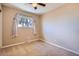 Neutral carpeted bedroom with a ceiling fan and a sunlit window provides a blank slate for personalization at 6233 W 75Th Ave, Arvada, CO 80003