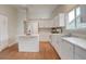 Bright kitchen with white cabinets, island, laminate floors, and modern appliances at 6522 S Hoyt Way, Littleton, CO 80123