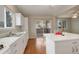 Eat-in kitchen features white cabinets, wood floors, and sliding glass doors to the outdoor deck at 6522 S Hoyt Way, Littleton, CO 80123