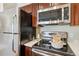 A well-equipped kitchen featuring stainless steel appliances, dark wood cabinets and modern fixtures at 10550 W Jewell Ave # 301, Lakewood, CO 80232