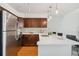 Modern kitchen featuring stainless steel appliances, dark wood cabinets and sleek countertops at 10550 W Jewell Ave # 301, Lakewood, CO 80232