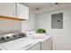 Laundry area with modern washer and dryer units, storage cabinets and a plant for decoration at 10550 W Jewell Ave # 301, Lakewood, CO 80232