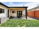 Inviting covered back patio with outdoor seating and views of the fenced yard and a small lawn at 401 S Ivy St, Denver, CO 80224