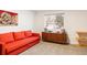 Cozy guest bedroom with a comfortable red sofa bed, mid-century cabinet, and natural light at 401 S Ivy St, Denver, CO 80224