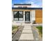Close-up of a modern home's entrance with a sleek door, stone walkway, and manicured landscaping at 401 S Ivy St, Denver, CO 80224