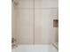 Clean bathroom featuring a white bathtub and tiled walls with a decorative accent at 3420 W 32Nd Ave # 203, Denver, CO 80211