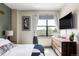 Bright bedroom with a large window, wooden dresser, and stylish artwork at 3420 W 32Nd Ave # 203, Denver, CO 80211