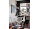 Cozy dining area with a round table, white chairs, and decorative shelves with books, plants, and photos at 3420 W 32Nd Ave # 203, Denver, CO 80211