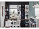 Stylish dining area featuring a white table, white chairs, shelves, and built-in bar storage for a modern and elegant aesthetic at 3420 W 32Nd Ave # 203, Denver, CO 80211