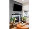 Inviting living room showcasing a fireplace with stone detailing and a large TV, complemented by plants and a round coffee table at 3420 W 32Nd Ave # 203, Denver, CO 80211