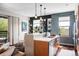 Well-lit kitchen with a breakfast bar, wood cabinets, pendant lights, and stainless steel appliances at 3420 W 32Nd Ave # 203, Denver, CO 80211
