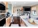 Open kitchen featuring wooden cabinets, a breakfast bar, and hardwood floors leading to the living area at 3420 W 32Nd Ave # 203, Denver, CO 80211