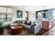 Open-concept living space with a large sectional sofa, round coffee table, and seamless transition to the kitchen at 3420 W 32Nd Ave # 203, Denver, CO 80211