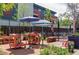 Charming outdoor patio area with umbrellas, seating, and book displays for a community gathering space at 3420 W 32Nd Ave # 203, Denver, CO 80211