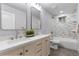 Bright bathroom features double sinks, white vanity, silver fixtures and modern tile design at 8079 W 67Th Ave, Arvada, CO 80004