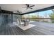Outdoor deck featuring a dining table, chairs, ceiling fans and railings with treetop views at 8079 W 67Th Ave, Arvada, CO 80004