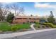 Well-maintained brick home with lush lawn, mature trees, and an inviting outdoor deck at 8079 W 67Th Ave, Arvada, CO 80004