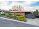 Charming home featuring a brick facade, well-manicured lawn, mature trees, and a spacious deck at 8079 W 67Th Ave, Arvada, CO 80004