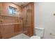 Modern bathroom featuring a walk-in shower with bronze fixtures, glass door, and textured tile at 8079 W 67Th Ave, Arvada, CO 80004