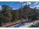 Aerial view of a cabin nestled in a snowy wooded area at 5925 Herzman Dr, Evergreen, CO 80439