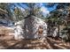 Exterior view of a small house in a wooded area at 5925 Herzman Dr, Evergreen, CO 80439