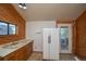 View of kitchen, with refrigerator, cabinets, and access to laundry at 5925 Herzman Dr, Evergreen, CO 80439