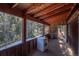 Covered porch overlooking a wooded area with a washer at 5925 Herzman Dr, Evergreen, CO 80439