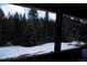 View from porch showcasing snowy landscape and trees at 5925 Herzman Dr, Evergreen, CO 80439