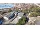 Elevated view of a modern home with an attached two-car garage and a private driveway nestled among mature trees and rock outcroppings at 6301 Perry Park Blvd # 22, Larkspur, CO 80118