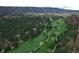 Aerial view of golf course with mature trees and mountain backdrop at 6301 Perry Park Blvd # 22, Larkspur, CO 80118