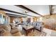 Spacious living room with wood paneling, beams, and stone fireplace transitions to dining at 6301 Perry Park Blvd # 22, Larkspur, CO 80118