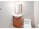 Bathroom features a wood vanity, a modern mirror, white toilet, and neutral colored walls at 6920 W 48Th Ave, Wheat Ridge, CO 80033