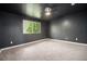 A carpeted bedroom has dark walls and ceiling along with a window for natural light and ceiling fan at 6920 W 48Th Ave, Wheat Ridge, CO 80033