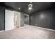 Spacious carpeted bedroom with mirrored closet doors, a ceiling fan, and an ensuite bathroom at 6920 W 48Th Ave, Wheat Ridge, CO 80033