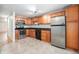 Well-lit kitchen features modern stainless steel appliances, wooden cabinets and ceramic tile floors at 6920 W 48Th Ave, Wheat Ridge, CO 80033
