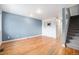 Spacious living room with hardwood floors, light blue accent wall, and staircase to upper floor at 6920 W 48Th Ave, Wheat Ridge, CO 80033