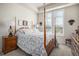 Main bedroom with wood post bed and plenty of natural light at 7865 Vallagio Ln # 308, Englewood, CO 80112