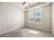 Bright bedroom with tray ceiling, neutral carpet, and window with stylish white shutters at 7865 Vallagio Ln # 308, Englewood, CO 80112