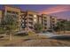 Attractive multi-unit building with landscaping and a sunset backdrop at 7865 Vallagio Ln # 308, Englewood, CO 80112