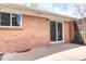 Brick exterior of a home with sliding glass door leading to a concrete patio at 10878 Patterson Ct, Northglenn, CO 80234