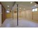 Unfinished basement with concrete floor, exposed beams, and natural light at 10878 Patterson Ct, Northglenn, CO 80234