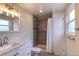 Bathroom with shower and bath featuring a tiled shower and white cabinets at 10878 Patterson Ct, Northglenn, CO 80234