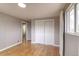 Bright bedroom featuring hardwood floors, closet, and a view to the bathroom at 10878 Patterson Ct, Northglenn, CO 80234