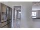 View of the entryway through the kitchen, featuring a steel fridge and tiled floors at 10878 Patterson Ct, Northglenn, CO 80234