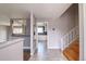 Inviting foyer with tile flooring, staircase, and a view into the kitchen and living areas at 10878 Patterson Ct, Northglenn, CO 80234