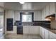 Bright kitchen featuring black appliances, tiled backsplash, countertops and white cabinets at 10878 Patterson Ct, Northglenn, CO 80234