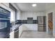 Well-lit kitchen with white cabinets, granite countertops, stainless steel appliances and black tiled backsplash at 10878 Patterson Ct, Northglenn, CO 80234