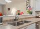 Close-up of a kitchen sink area with a view to the living area, featuring modern fixtures at 5800 Tower Rd # 610, Denver, CO 80249