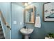 Small powder room with pedestal sink and beach-themed art at 9624 Martin Luther King Blvd, Denver, CO 80238