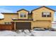 Tan two-story home with a two-car garage and snow-covered driveway at 9624 Martin Luther King Blvd, Denver, CO 80238